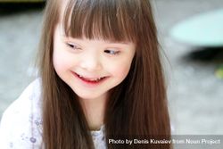 Portrait of a young girl with Down syndrome looking away from the camera bx31d4