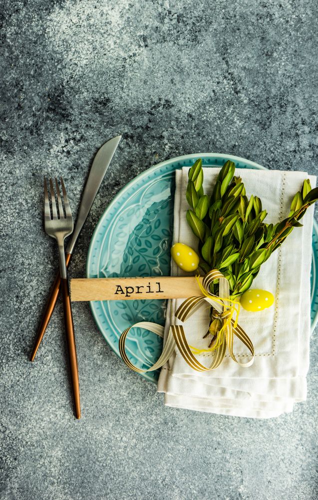 Easter card concept of branch and yellow mini eggs on table setting
