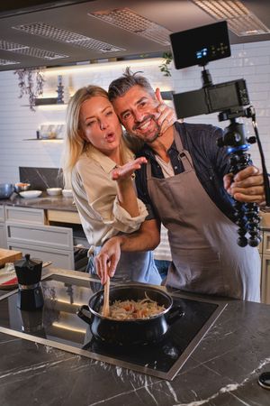 Couple taking photo while cooking