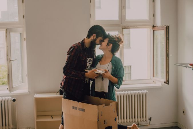 Casual couple unpacking boxes in apartment