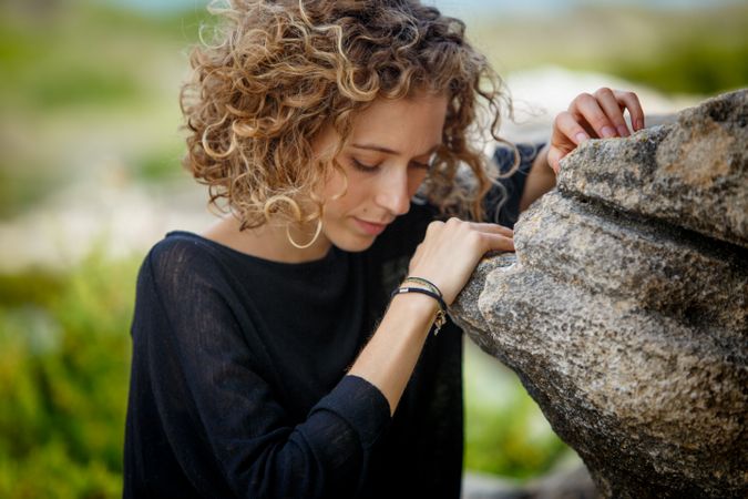 Young woman posing near stone