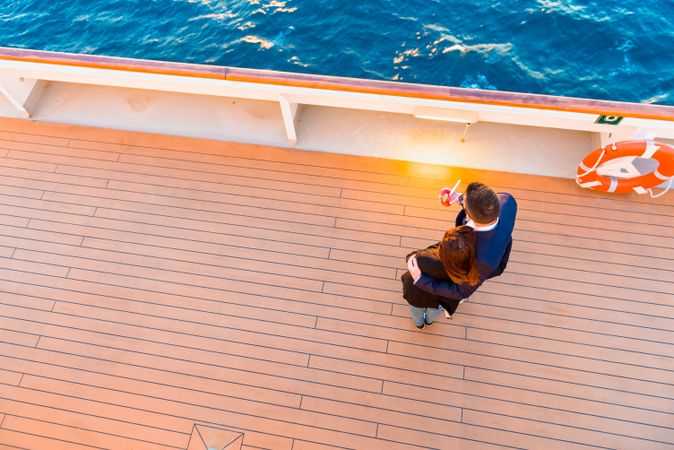 Couple hugging on deck of ship in blue sea