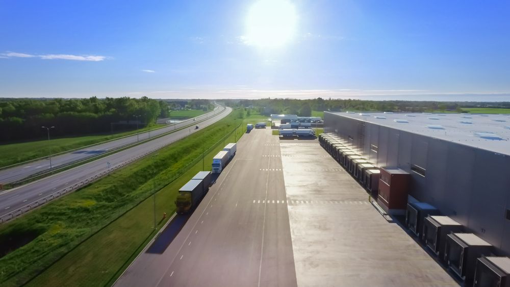 Aerial Shot of Industrial Warehouse  where Many Trucks Are Loading