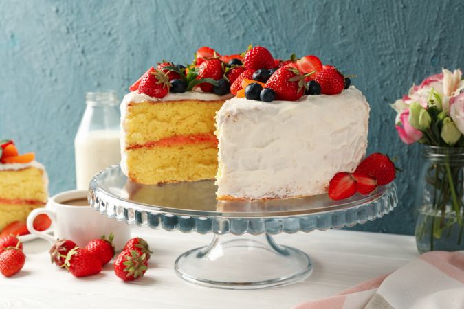 Composition with delicious berry cream cake on wooden table. Tasty dessert