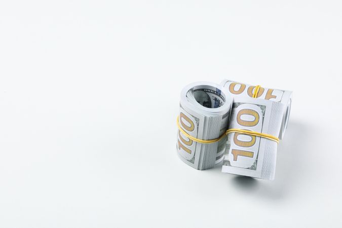 Twisted money with a rubber band, on a light background.