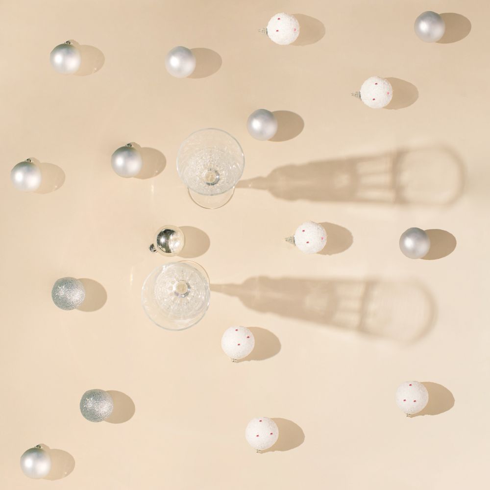 Top view of champagne glasses surrounded by Christmas baubles