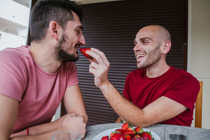 Gay couple eating strawberries
