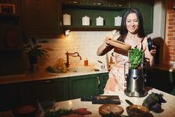 Staying at home woman using mixer for to prepare vegetarian food