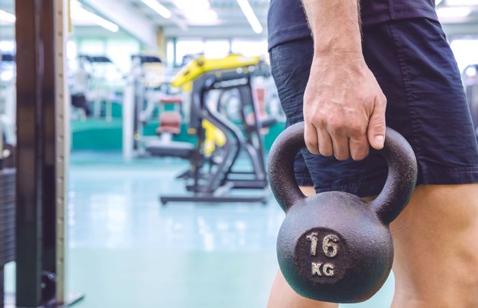 Side view of man holding kettle bell