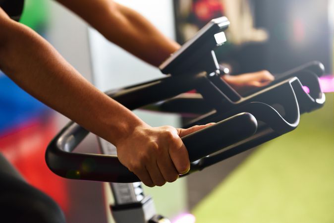 Hands of a female training at a gym doing indoor biking