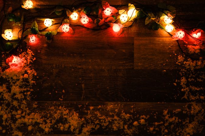 String of Christmas lights on dark wooden board