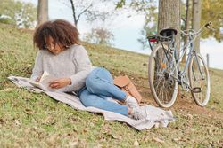 Black female reading interesting book in nature