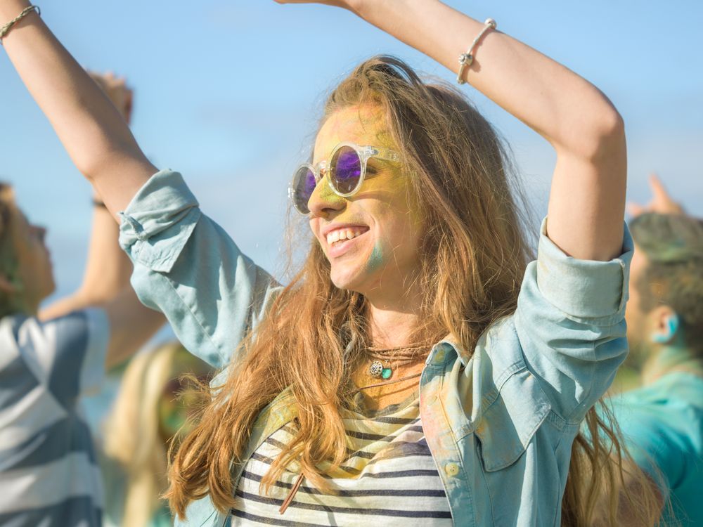 Woman's Face and Clothes are Covered with Colorful Powder.