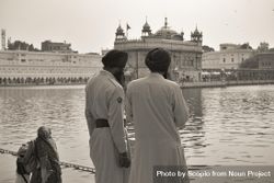 Grayscale photo of two men wearing turban standing beside body of water bYrV90