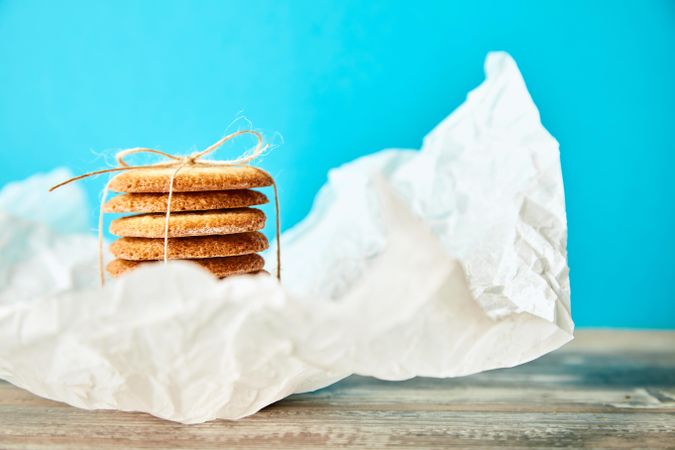 Side view of stack of sugar cookies on blue background