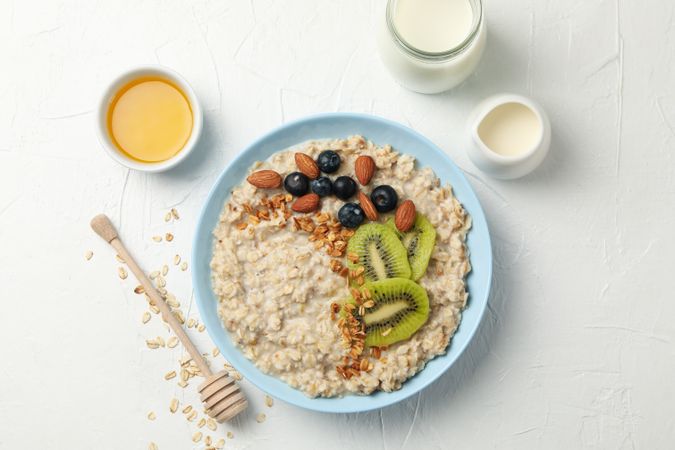 Composition with oatmeal with fruits on blank background