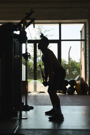 Black guy using exercise machine in gym