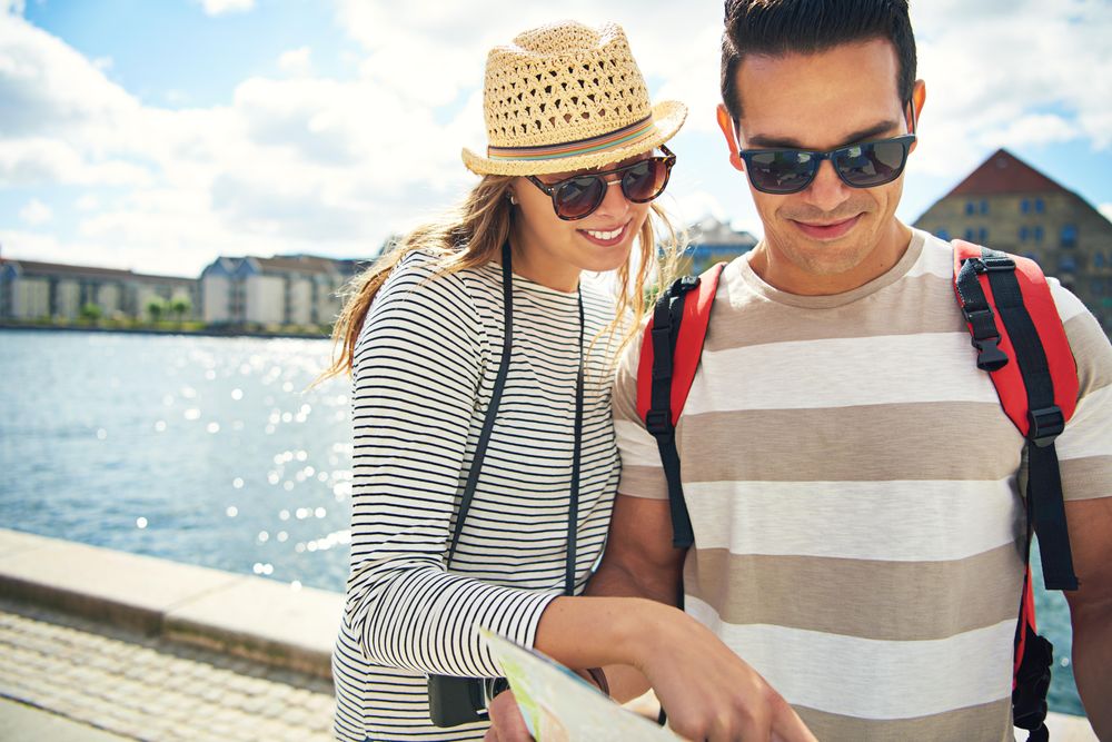 Cute couple consulting map on holiday