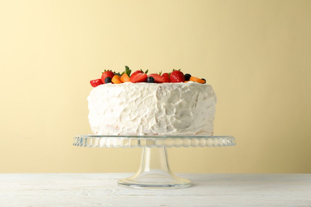 Berry cream cake on wooden table. Delicious dessert