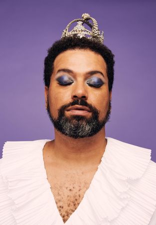 Portrait of a beard man with makeup and crown