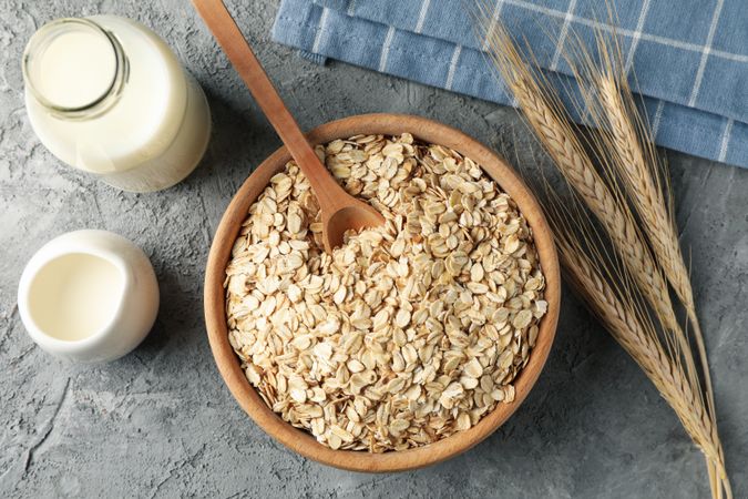 Composition with oatmeal flakes on gray background. Cooking breakfast