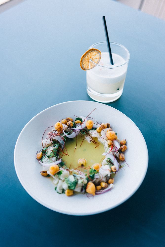 Seafood and saffron dish with cocktail on restaurant table