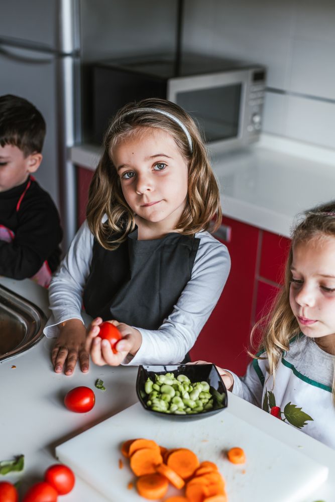 Siblings preparing vegetables for salad