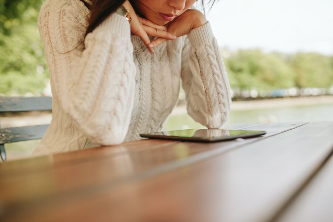Close up image of woman sitting at cafe table with digital tablet