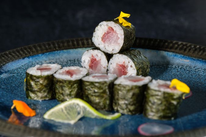 Appetizing sushi rolls with salmon on marble plate