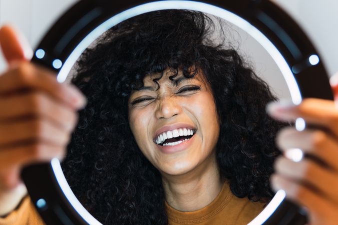 Excited Black woman with ring lamp