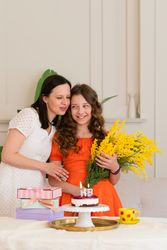 Girl in orange dress celebrating birthday with mom