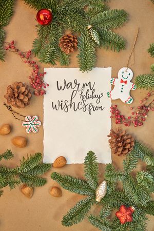 Christmas greeting written with a beautiful handmade letter with Christmas decorations and lights around.