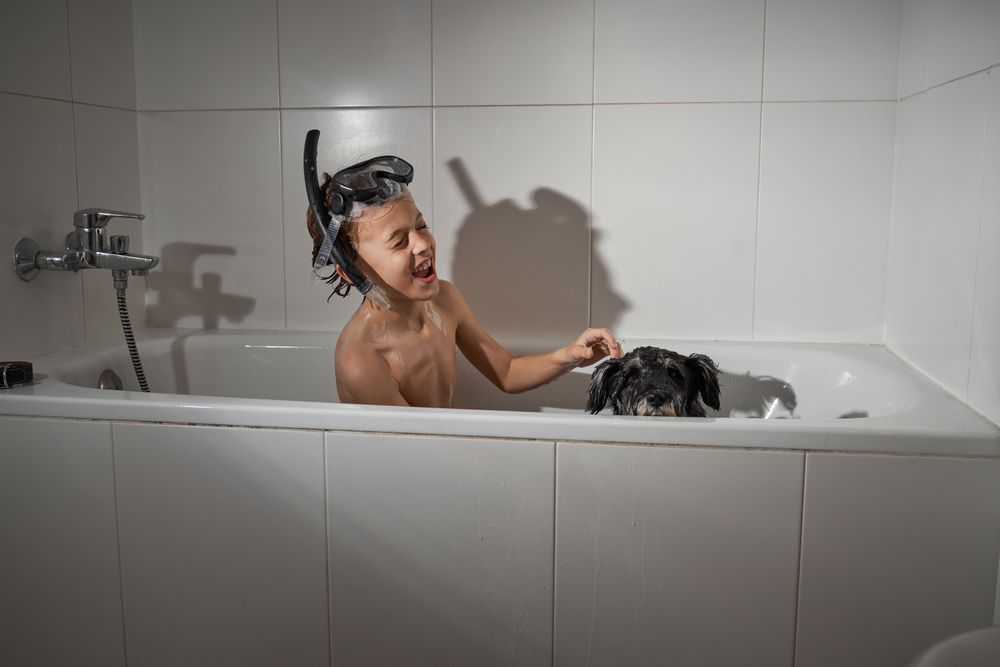 Happy boy with dog in tub