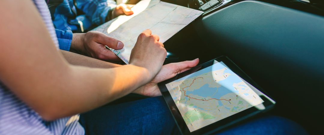 Couple comparing paper map and a gps navigator
