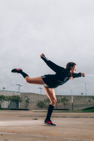 Female hip hop dancer in active wear striking pose outdoors