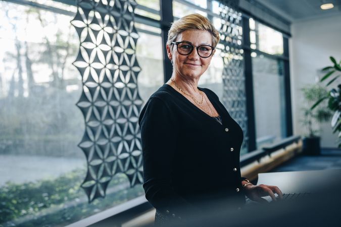 Portrait of mature businesswoman looking at camera while working in office