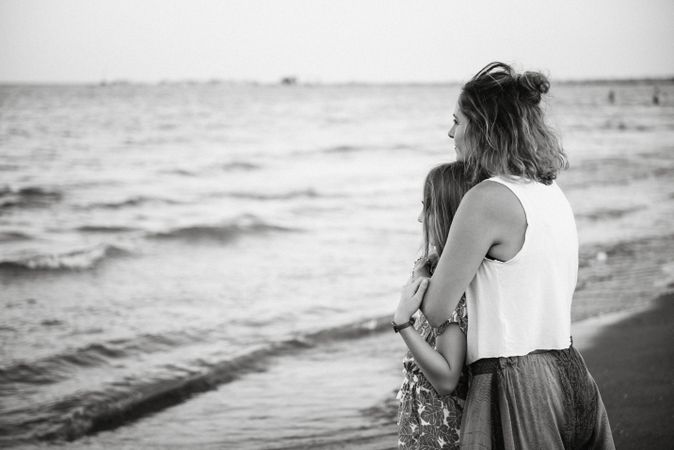 Beautiful mother and daughter embracing on beach