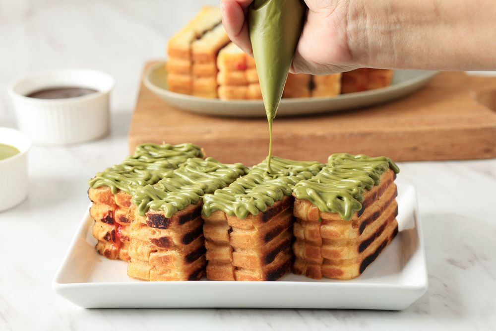 Pouring Matcha Sauce on Top of Roti Bakar Bandung
