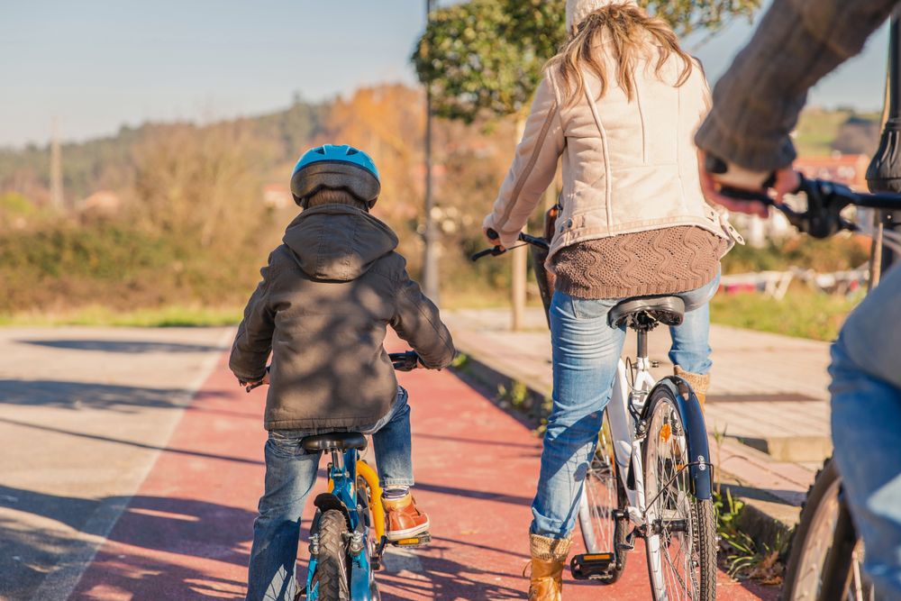 Back of mother and son on family bike ride together