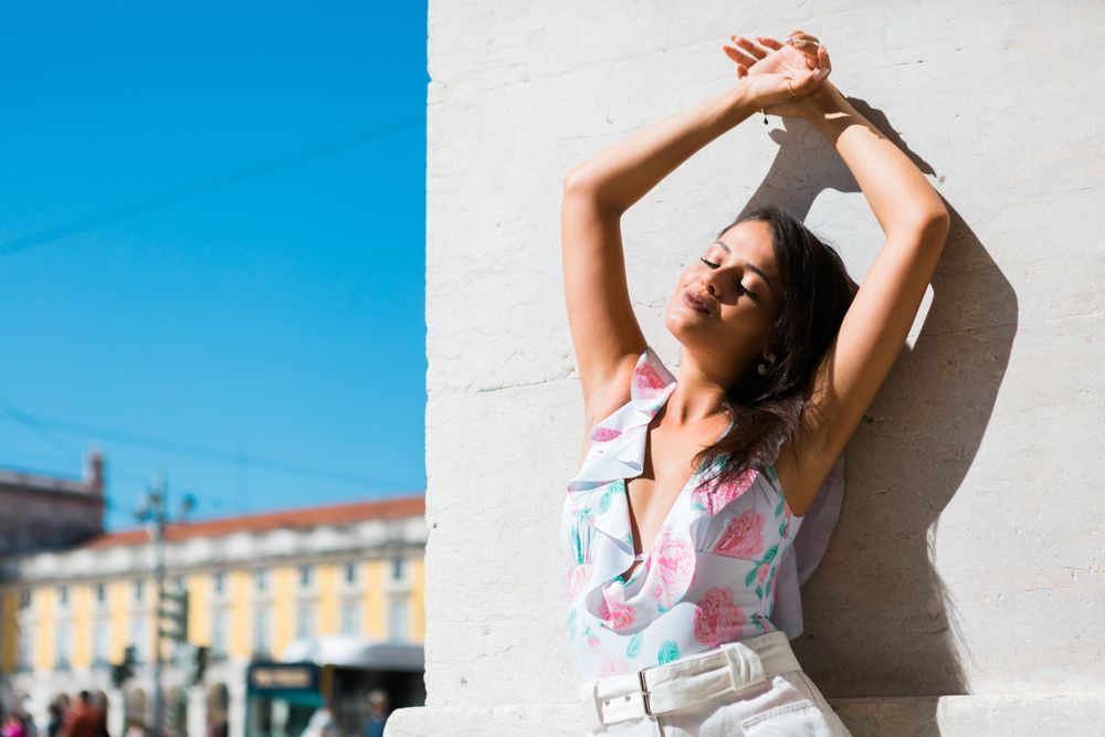 Dreamy stylish woman standing on city street
