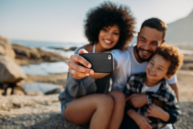 Man using a mobile phone to shoot a selfie with his family