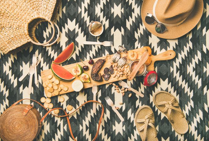 Summer picnic on pueblo pattern blanket, with board of pate, meats, and fruit