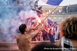 Man holding blue flag near crowd at festival 5r7yl4