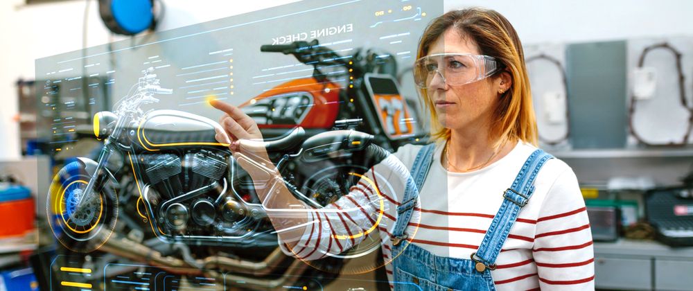 Female mechanic using hud panel screen with augmented reality hologram to review motorcycle