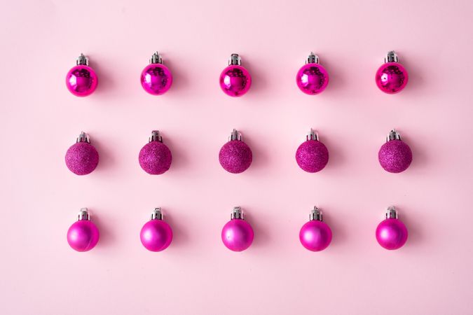 Arrangement of pink festive baubles in rows on pink background