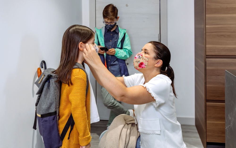 Mother putting the mask on her daughter
