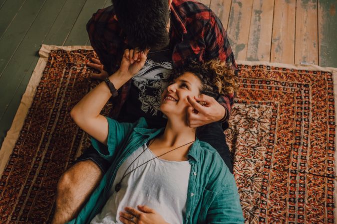 Happy couple embracing on carpet at home