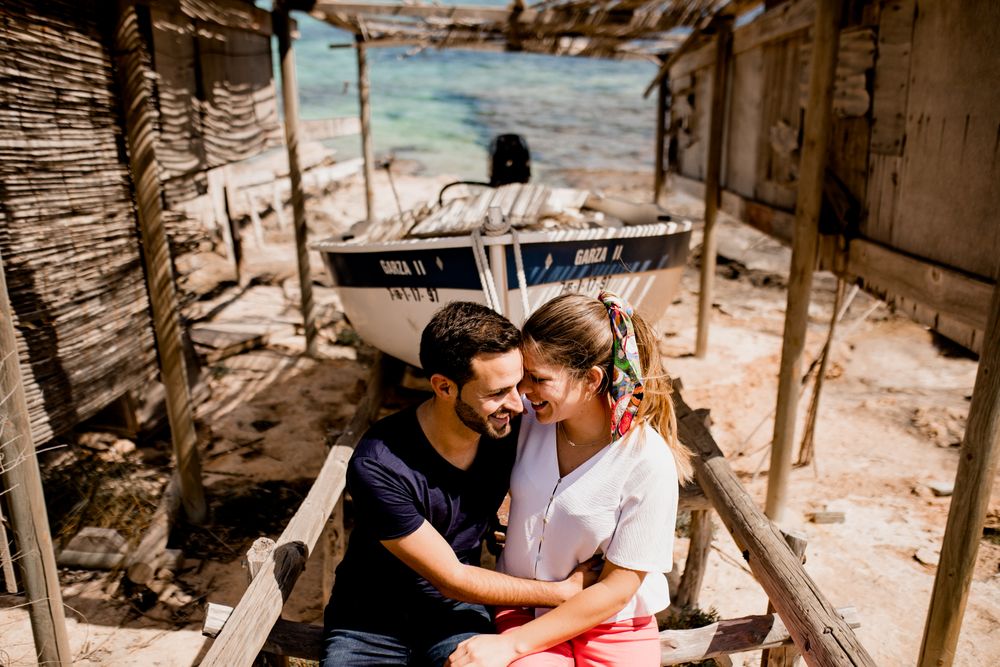 Loving couple hugging near boat dragged ashore