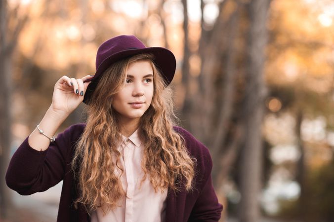 Portrait of teenage girl with purple hat looking away