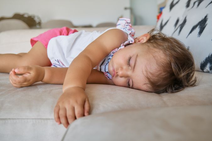 Adorable toddler sleeping on cozy sofa at home